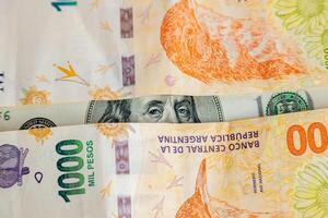 un cent dollar facture entre deux mille argentin peso factures. concept de argentin économie. photo