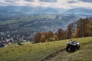 gris quad bicyclette sur le Montagne pente surplombant le ville au dessous de photo