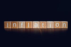 en bois blocs forme le texte inflation contre une noir Contexte. photo