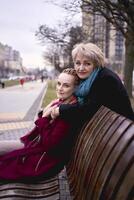 un vieux mère câlins sa fille sur une printemps rue photo