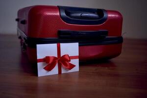 une cadeau certificat dans rouge et blanc couleurs sur une rouge valise pour Voyage photo