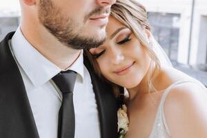 le la mariée et jeune marié embrasser. le la mariée doucement câlins le jeune marié par le épaules. magnifique mariage couple. le concept de romance dans une jeunes mariés relation. voyage de noces. photo