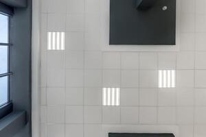 plafond tendu ou suspendu à cassette avec lampes halogènes carrées et construction de cloisons sèches dans une pièce vide de la maison ou du bureau avec colonne. vue en l'air photo