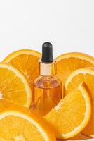 vitamine c sérum extrait avec tranché des oranges sur blanc Contexte. Naturel peau se soucier produits de beauté. maquette avec copie espace photo