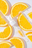 proche en haut de pipette avec verser liquide sérum et ombres sur des oranges Contexte. branché produits de beauté coup avec difficile ombres photo