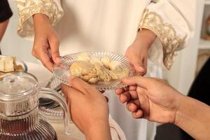 femelle main servir assiette de nourriture avec ketupat et opor photo