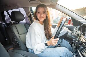 côté portrait de Jeune caucasien femme conduite voiture dans le ville photo