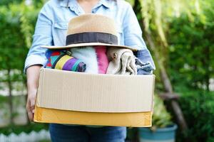 bénévole collecte tissu et chapeau dans papier carton boîte à donner. photo