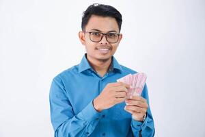 sourire ou content asiatique employé homme avec des lunettes en portant argent portant bleu chemise isolé sur blanc Contexte photo