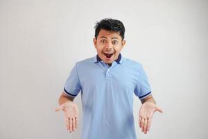 choc asiatique homme avec ouvert mains et bouche portant bleu t chemise isolé sur blanc Contexte photo