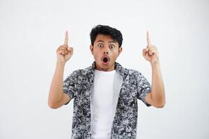 choc Jeune asiatique homme montrer du doigt en haut avec gros yeux et bouche ouvrir, sous le choc surpris expression isolé photo