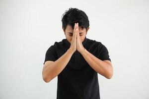 portrait de musulman asiatique homme portant noir polo t chemise avec tous les deux mains donnant salutation isolé sur blanc Contexte photo