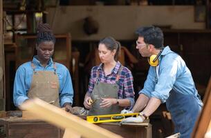 Charpentier et le sien assistant travail ensemble dans une charpenterie atelier photo