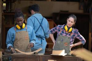 Charpentier et le sien assistant travail ensemble dans une charpenterie atelier photo