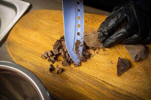 femme cuisine savoureux fondu Chocolat sur table dans cuisine. photo