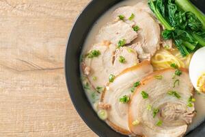 nouilles ramen dans une soupe d'os de porc avec du porc rôti et des œufs photo