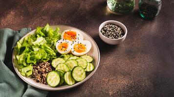bol avec quinoa, concombre, bouilli œuf, salade et sésame des graines la toile bannière photo