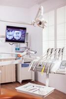 fermer vue de dentaire outils et professionnel chaise à dentiste. stomatologie cabinet avec personne dans il et Orange équipement pour oral traitement. photo