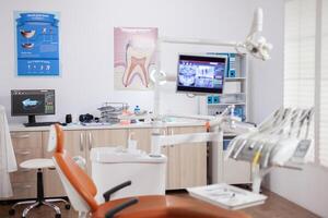 moderne Orange dentiste cabinet avec stérile ustensiles. stomatologie cabinet avec personne dans il et Orange équipement pour oral traitement. photo