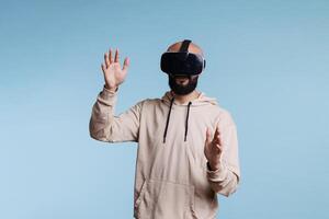 homme immergé dans virtuel réalité portant casque et fabrication geste avec mains. Jeune la personne explorant métaverse dans vr casque, profiter cyberespace divertissement loisir activité photo