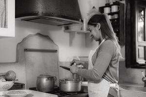 Latin femme en train de préparer nourriture recette dans sa maison - noir et blanc édition photo