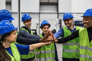 équipe de multiracial ingénieurs empilage mains ensemble à l'intérieur robotique usine - technologie industrie concept photo