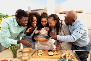 content africain famille en train de préparer nourriture recette ensemble sur maison patio photo