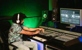 Jeune l'audio ingénieur mélange une des sons dans la musique enregistrement studio - jeunesse musicien gens mode de vie concept photo