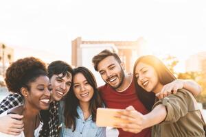 groupe multiracial copains prise selfie avec mobile téléphone intelligent Extérieur - content mixte course gens ayant amusement Extérieur - jeunesse millénaire génération et Multi-éthnique adolescents mode de vie concept photo
