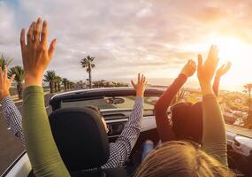 content copains ayant amusement dans convertible voiture à le coucher du soleil dans vacances - Jeune gens fabrication fête et dansant dans une cabrio auto pendant leur route voyage - amitié, voyage, jeunesse mode de vie concept photo