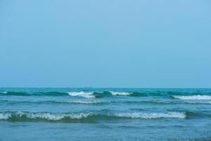 vagues sur le plage. bleu mer vague. bleu l'eau surface texture avec ondulations, éclaboussures, et bulles. abstrait été bannière Contexte l'eau vagues dans lumière du soleil avec copie espace cosmétique Crème hydratante. photo