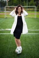 portrait de une magnifique femme Football joueur dans une strict Bureau costume. photo