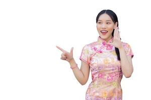 asiatique femme avec longue cheveux qui porte rose cheongsam robe dans chinois Nouveau année thème tandis que sa main spectacles à présent et montrant main à point tandis que isolé blanc Contexte. photo