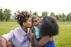 content africain famille ayant amusement ensemble dans Publique parc - noir père et mère profiter fin de semaine avec leur fille - gens l'amour et parent unité concept photo