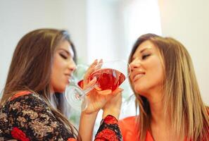 content Jeune femmes ayant amusement en buvant du vin à Accueil - de bonne humeur copains applaudissement avec des cocktails - gens mode de vie concept photo