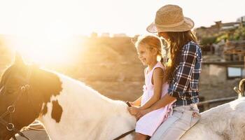 content famille mère et fille ayant amusement équitation cheval à l'intérieur ranch photo