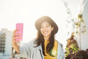 asiatique fille prise selfie avec mobile téléphone intelligent Extérieur - content chinois femme ayant amusement avec Nouveau les tendances La technologie applications - millénaire génération et technologie gens intoxiqué concept photo