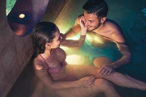 romantique couple Faire une nager bassin spa centre la Saint-Valentin journée - content les amoureux ayant soumissionner moment sur vacances dans recours bien-être Hôtel - gens relation, des loisirs, relaxation et l'amour concept photo