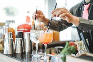 barman en train de préparer différent des cocktails mélange avec pailles à l'intérieur bar - profession, travail et mode de vie concept - doux concentrer sur Haut de premier verre photo