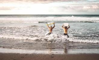 content en forme copains ayant amusement surfant sur le coucher du soleil temps - gens Faire formation des exercices dans école surfeurs - sportif en bonne santé mode de vie et extrême sport concept photo