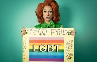traîne reine célébrer gay fierté en portant bannière avec arc en ciel drapeau - lgbtq social communauté concept photo