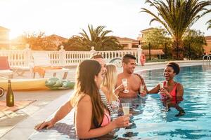 groupe de content copains fabrication une bassin fête à le coucher du soleil - millénaire Jeune gens en riant et ayant amusement en buvant Champagne dans le bassin - amitié, vacances et été jeunesse mode de vie concept photo