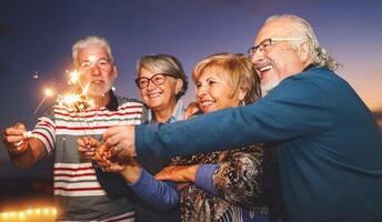 content Sénior famille célébrer avec cierge magique feux d'artifice à Accueil fête - personnes âgées gens mode de vie et vacances concept photo