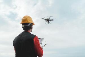 Masculin ingénieur surveillance construction site avec drone - La technologie et industriel concept photo