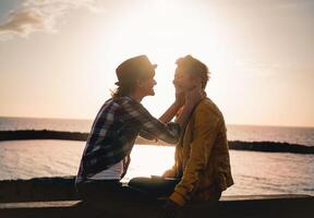 content gay couple sortir ensemble suivant le plage à le coucher du soleil - Jeune lesbienne femmes ayant une soumissionner romantique moment Extérieur - lgbt, homosexualité l'amour et mode de vie relation concept photo