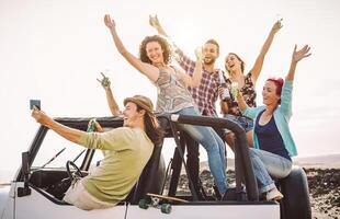 content copains prise selfie avec mobile intelligent téléphone sur convertible voiture - millénaire Jeune gens ayant amusement fabrication fête pendant leur route voyage - vacances, technologie et jeunesse vacances mode de vie concept photo