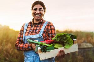 une femme en portant une boîte de Frais des légumes photo