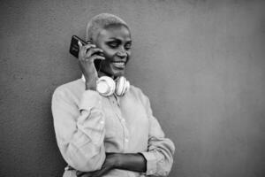 content souriant africain femme Faire une appel avec mobile téléphone intelligent Extérieur - noir et blanc édition photo