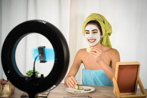 content Jeune femme vlogging sur social réseau tandis que ayant peau se soucier spa journée - gens bien-être et La technologie concept photo