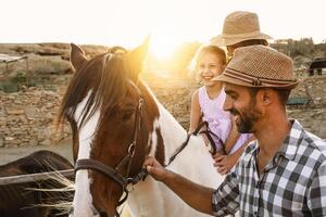 content famille ayant amusement équitation sur cheval à l'intérieur ranch photo